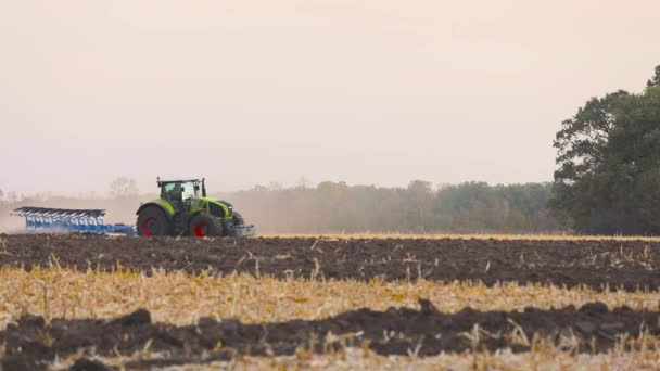 Ciągnik w terenie. Nowoczesny traktor zaorał pole. Zielony ciągnik pługa pole — Wideo stockowe