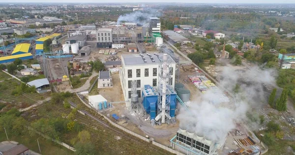 Modern bir bitkinin üzerinden uçmak. Üst görüşü yerleştir. Bitkiden yoğun beyaz duman.