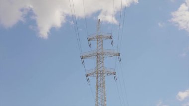 Elektrik taşıma hattı. Elektrik direkleri zaman atlaması, arka planda bulutlar. Yüksek voltajlı kule. Elektrik direklerinin arka planında güzel bulutlar zaman aşımına uğrar