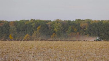 Yeşil traktör tarlayı sürüyor. Traktör sahada. Modern bir traktör tarlayı sürüyor..