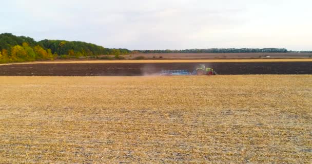 Traktor fungerar i fältet ovanifrån. Flyger över traktorn på fältet. Traktorn plöjer fältet. — Stockvideo
