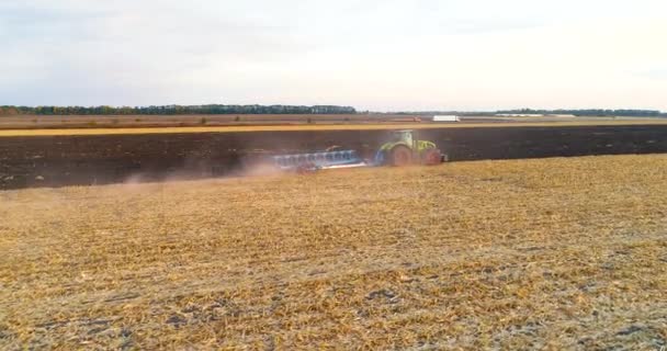 O tractor trabalha no terreno. Voando sobre um trator que trabalha no campo. Tractor arado a vista aérea de campo. Voe sobre o campo com um trator — Vídeo de Stock