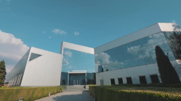 The clouds are reflected in the mirrored windows of the office building in time laps — Stock Video