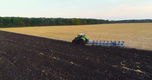 Volando sobre el tractor en el campo. Tractor trabaja en la vista de campo. El tractor arada el campo. — Vídeo de stock