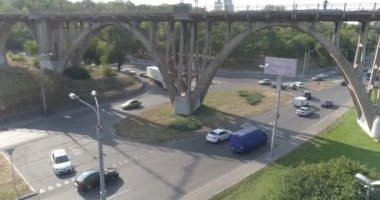 Arabalar büyük bir şehrin seddi boyunca seyahat ederler. Nehrin kenarındaki büyük bir şehirde. Sur boyunca uzanan yol..