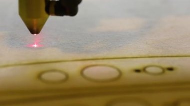 Bir lazer cnc makinesinde ahşap bir parça oluşturma süreci, cnc makinesiyle ağaçtan bir parça kesme işlemi. Kırmızı lazer bir tahtayı keser