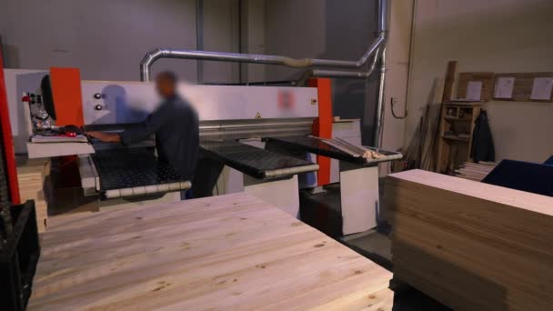 Un uomo lavora per la macchina in una fabbrica di mobili, interni industriali — Video Stock