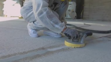 Beton yüzey öğütme. İnşaatçılar zemini özel ekipmanlarla cilalıyorlar. İnşaat alanında inşaatçılar