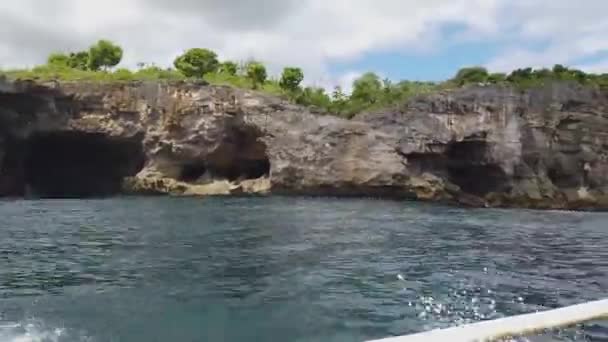 De boot drijft langs de levende rotsen, prachtige rotsen aan de kust van Bali — Stockvideo