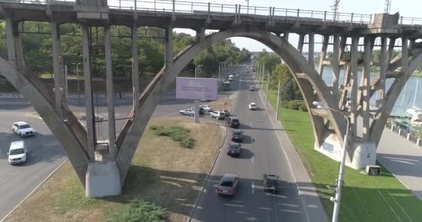 Car traffic. Cars drive along the road in the city top view. Cars pass under the bridge. Many cars on the road passing under the bridge top view — Stock Video