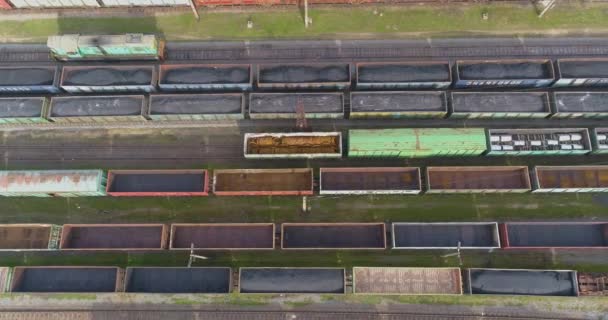 Los trenes de colores se encuentran en un gran depósito ferroviario. Gran depósito de trenes. Enlace ferroviario con una gran cantidad de rieles vista superior. — Vídeo de stock