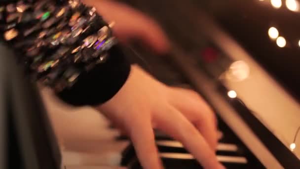 Крупним планом руки грають у синтезатор. дівчина грає синтезатор. Синтезатор з різдвяними прикрасами крупним планом — стокове відео