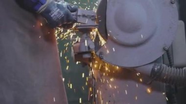 Parçalama çarkının bir parçasını öğütmekten kıvılcımlar çıkıyor. Değirmen çarkında metal bir parça işleniyor. Parlak kıvılcımlar metal bir parçayı makinelemekten.