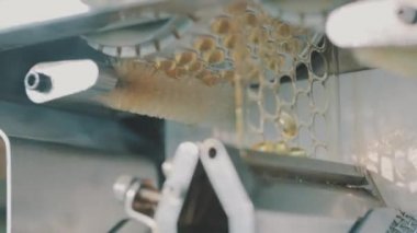 Jelatinimsi kabuklu yakın plan tablet üretimi. Modern bir fabrikada tablet üretimi. Tabletle birlikte fabrika taşıma hattında uyuşturucu üretim süreci