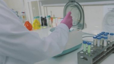 Maskeli laboratuvar asistanı. Laboratuvar çalışanı. Laboratuvarda çalışan bir kadın.