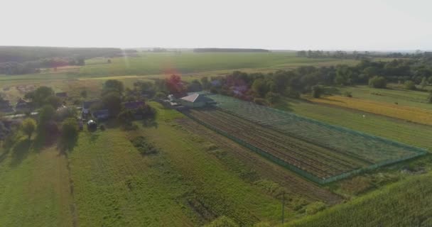 Petite ferme à la campagne au coucher du soleil. Agriculture vue aérienne. Ferme de l'air. Survolez un petit air à la campagne. — Video