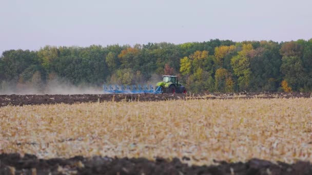 Трактор вспахивает сельскохозяйственное поле. Обработка поля трактором. Трактор обрабатывает поле. — стоковое видео