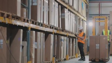 Bir depoda iki işçi iş hakkında konuşuyor. Fabrika deposundaki mühendisler.