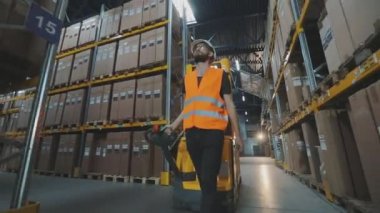 Depo işçisi kargo taşıyor. Depo işçisi kutuları taşıyor.