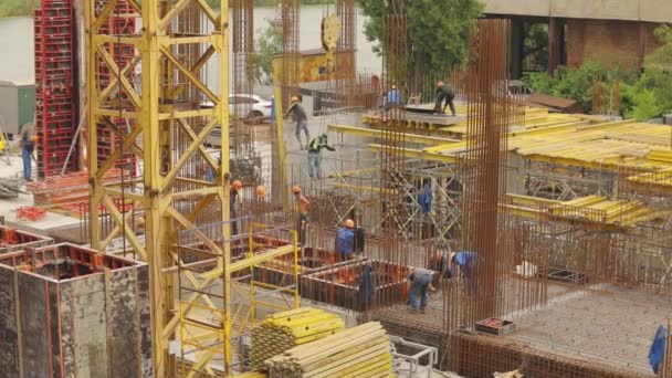 Construcción de hormigón armado. Trabajadores en una obra de construcción. La gente está trabajando en la construcción de una nueva casa. — Vídeos de Stock