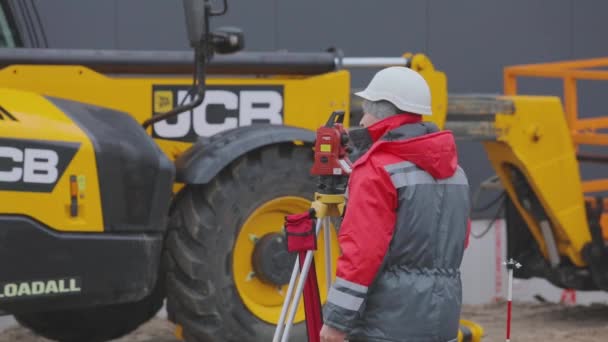 Inspektor na staveništi, zeměměřič provádí měření na staveništi — Stock video