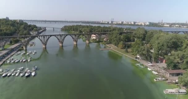 横跨河流的铁路桥.一座大城市过河的桥.在一座大城市的河上铁路桥附近飞行 — 图库视频影像