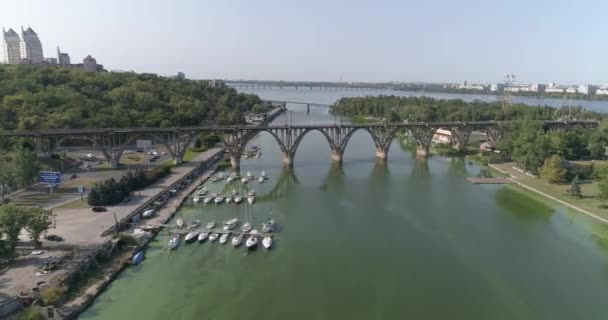 Pont sur la rivière dans une grande ville. Vol près du pont ferroviaire au-dessus de la rivière dans une grande ville. Pont ferroviaire traversant la rivière. — Video