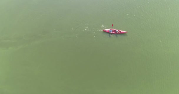Leć nad kajakiem w jeziorze. Para pływa kajakiem po jeziorze. Ludzie pływają po jeziorze na kajaku widok z góry. — Wideo stockowe