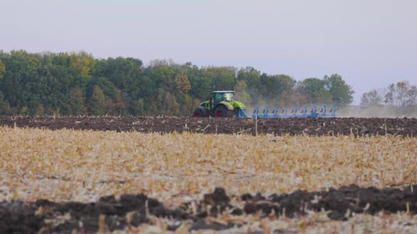 Ciągnik w terenie. Nowoczesny traktor zaorał pole. Zielony ciągnik pługa pole — Wideo stockowe