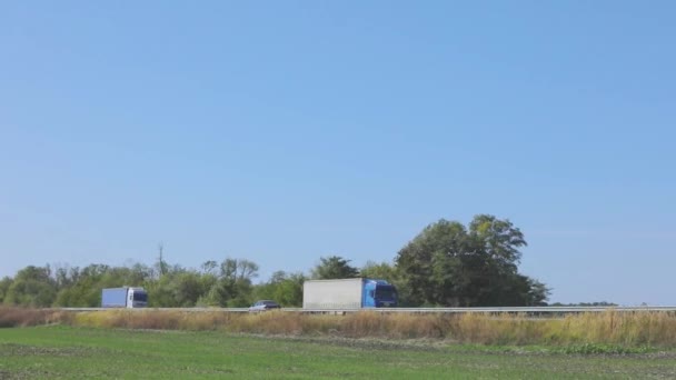 De truck rijdt op de snelweg. De truck rijdt op de snelweg rond de velden en bomen — Stockvideo