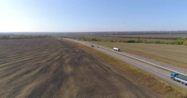 Kamyon tarlaların üst manzarası boyunca gider. Kamyon güneşli havada tarlalar boyunca sürer. Güzel bir yolda kamyon sürüyor.