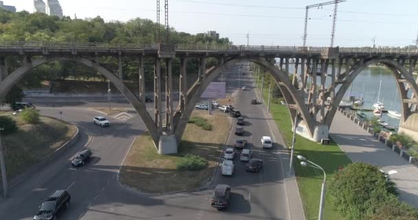 Autos fahren im Stadtblick die Straße entlang. Autos passieren die Brücke. Viele Autos auf der Straße, die unter der Brücke vorbeifahren. Autoverkehr. — Stockvideo