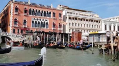 Gondollar iskeleye yakın. Büyük Kanal 'da demirli gondollar, arka arkaya birkaç gondol..