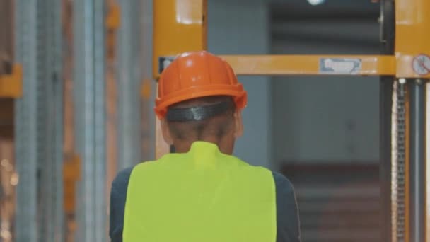 Un hombre atraviesa un almacén. Un trabajador camina por un almacén moderno en cámara lenta — Vídeo de stock