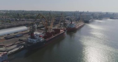 Büyük bir limanın genel planı, liman üzerinde kargo gemileriyle uçmak. İskele vinçleri ve büyük kargo gemileri üzerinde uçmak