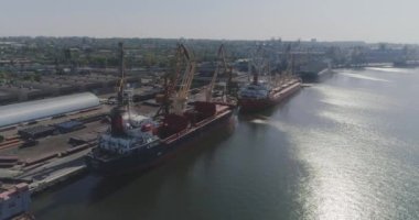 Büyük bir limanın genel planı, liman üzerinde kargo gemileriyle uçmak. İskele vinçleri ve büyük kargo gemileri üzerinde uçmak