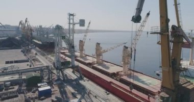 Büyük bir sanayi limanının üzerinde uçuyor. Uluslararası sanayi limanı, vinçler ve kargo gemileri