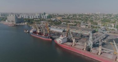 Limanda kuru kargo gemisi var. İskele vinci kargoyu kuru bir kargo gemisine yüklüyor.
