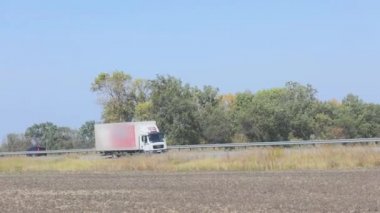 Vagon yazın güzel bir yol boyunca sürer. Bir araba mavi gökyüzüne doğru yol alır