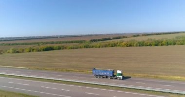Kamyon uzun, düz bir yol boyunca gider. Kamyon yol boyunca gidiyor, doğa etrafta. Vagon, İHA ateşi altında yol boyunca gidiyor.