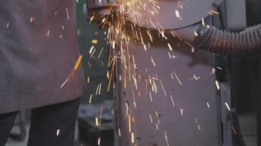 Parlak kıvılcımlar metal bir parçayı makinelemekten geliyor. Parçalama çarkının bir parçasını öğütmekten kıvılcımlar çıkıyor. Değirmen çarkında metal bir parça işleniyor..