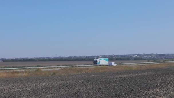 O caminhão dirige em uma estrada moderna plana fora da cidade. O caminhão está dirigindo ao longo da estrada em um dia de sol — Vídeo de Stock