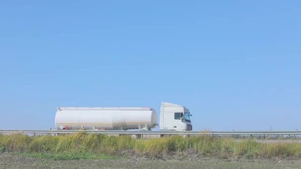 El camión de combustible está conduciendo por la carretera. Camión de combustible conduciendo en la carretera fuera de la ciudad — Vídeos de Stock