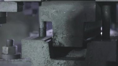 Makinenin bir parçasını bükmek. Makinede metal bir parça damgalanıyor.