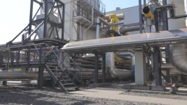 Fabrikada bir sürü büyük parlak borular var. Büyük metal parlak borular. Endüstri dışı