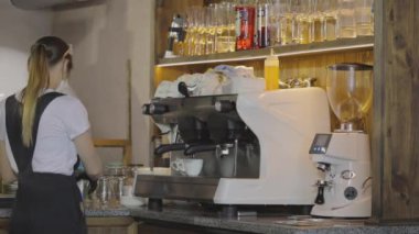 Genç bir barista kahve yapıyor. Şık bir kahve dükkanında kahve yapmak.