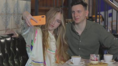 Arkadaşlar selfie çeker. Kızlı adam selfie çekiyor.