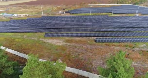 Pohled na solární elektrárnu shora, let nad velkou solární stanicí poblíž lesa — Stock video