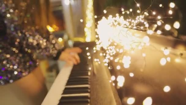 Girl plays the synthesizer. Close-up of hands playing the synthesizer. Synthesizer with Christmas decorations close-up — Stock Video