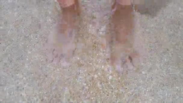 Vatten sköljer en mans fötter. Manliga fötter i havsvågorna. Fötter i havsvatten närbild — Stockvideo